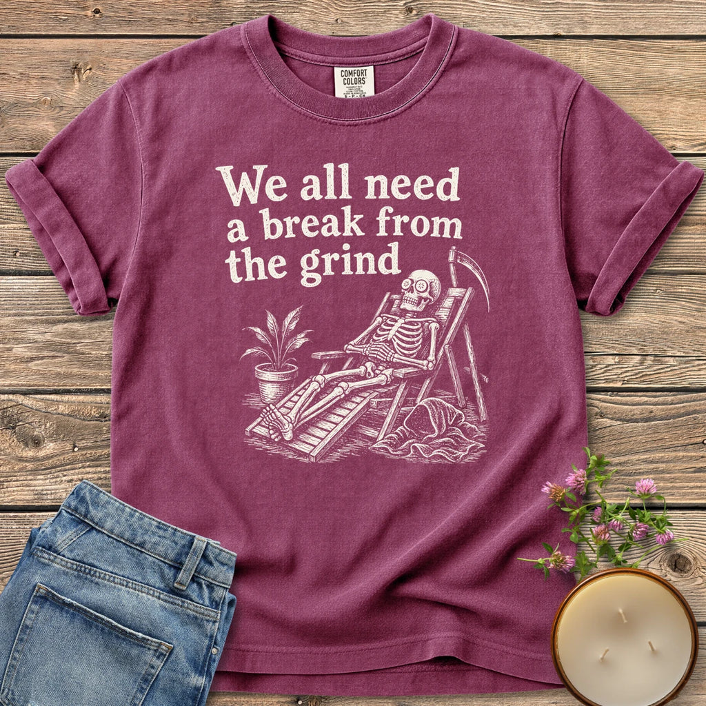 A Break From the Grind t-shirt, a skeleton relaxing in a beach chair with a houseplant under We all need a break from the grind, on a Berry Comfort Colors tee