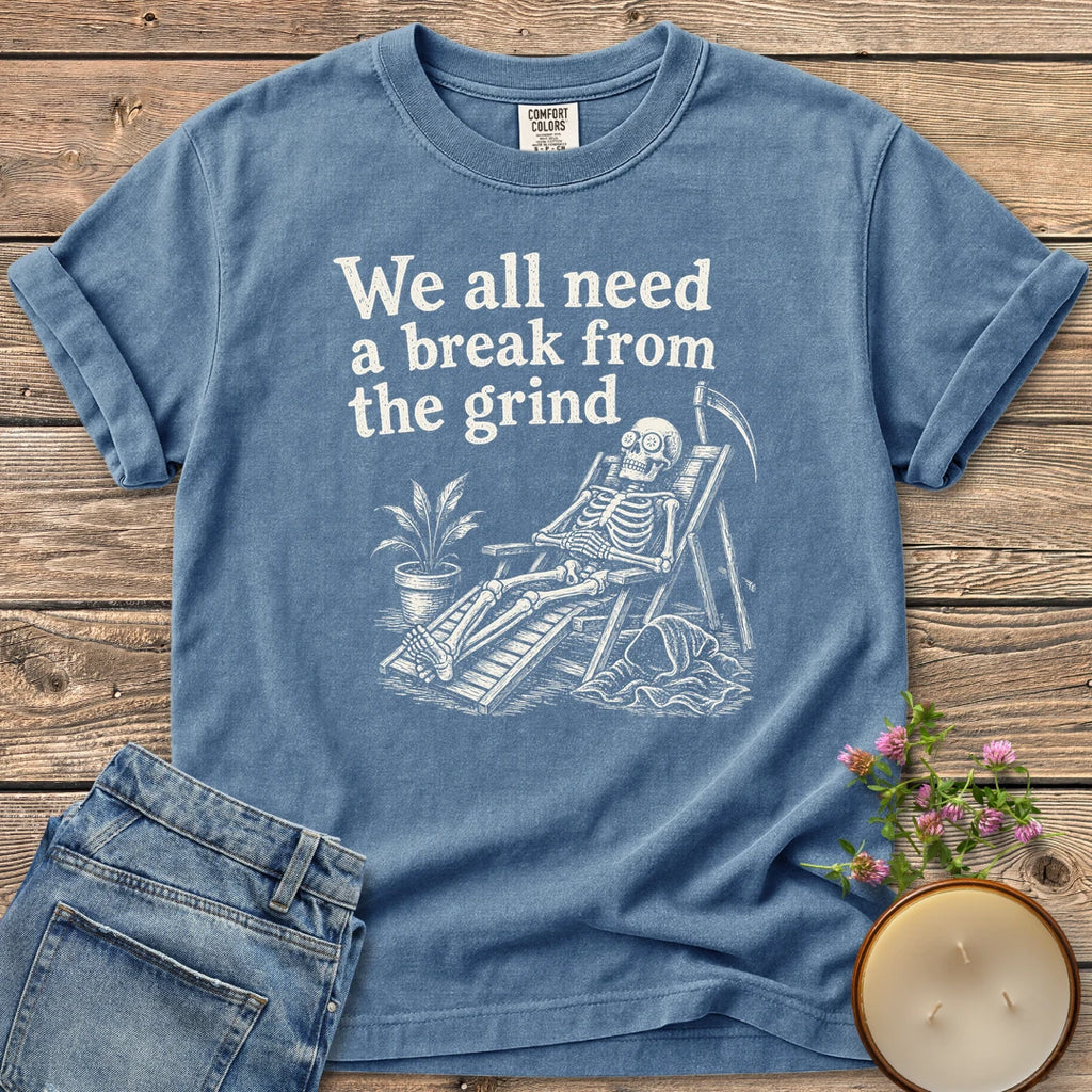 A Break From the Grind t-shirt, a skeleton relaxing in a beach chair with a houseplant under We all need a break from the grind, on a Blue Jean Comfort Colors tee