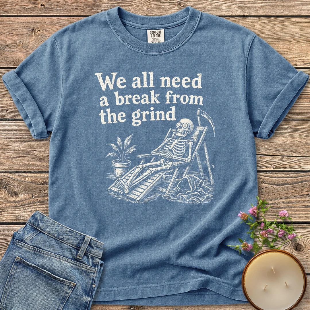 A Break From the Grind t-shirt, a skeleton relaxing in a beach chair with a houseplant under We all need a break from the grind, on a Blue Jean Comfort Colors tee