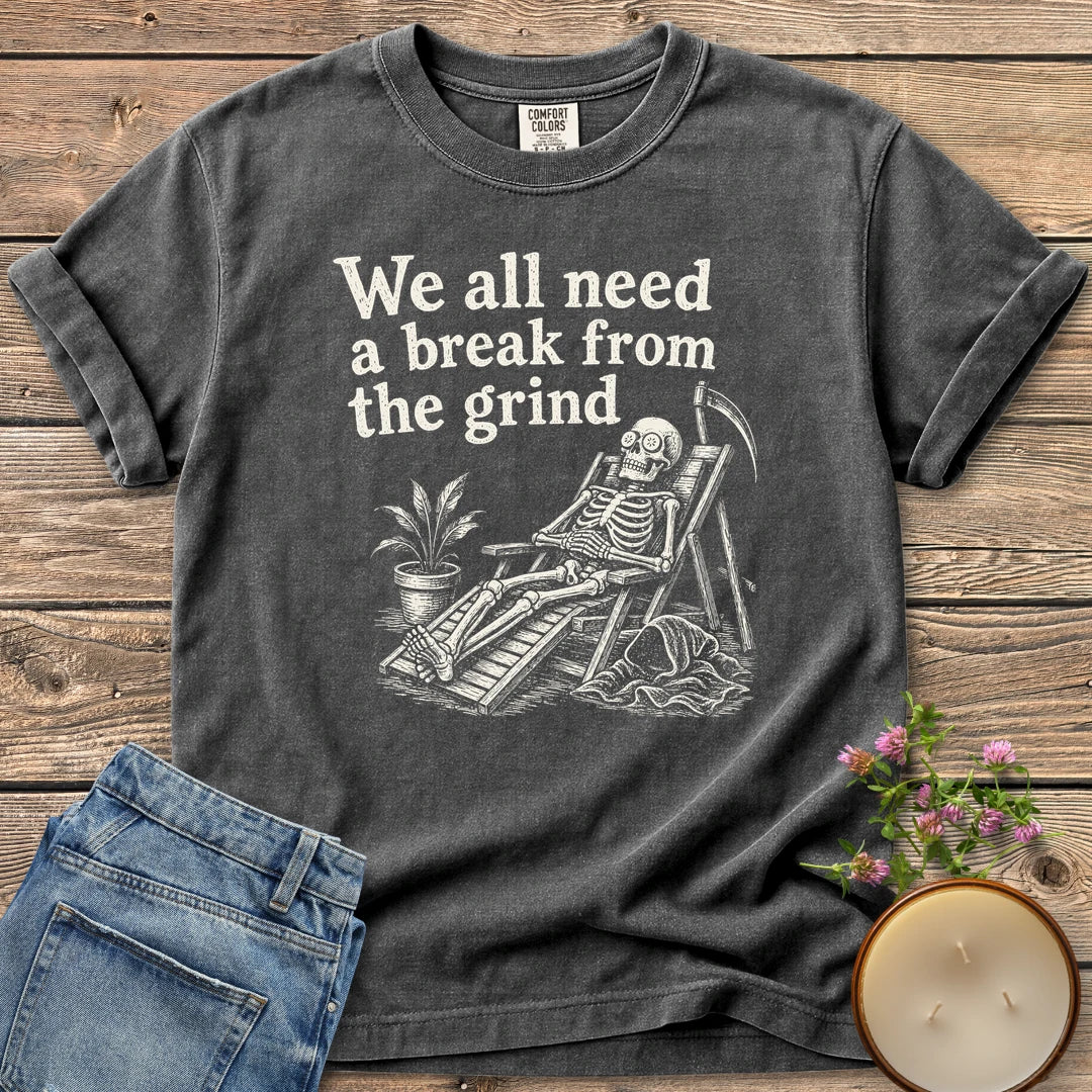 A Break From the Grind t-shirt, a skeleton relaxing in a beach chair with a houseplant under We all need a break from the grind, on a Pepper Comfort Colors tee