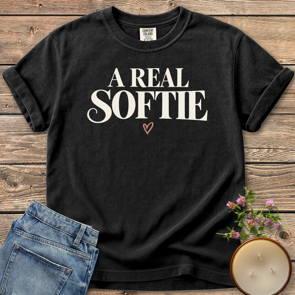 A Real Softie Vintage t-shirt, A Real Softie in vintage serif type with a small heart, on a Black Comfort Colors tee