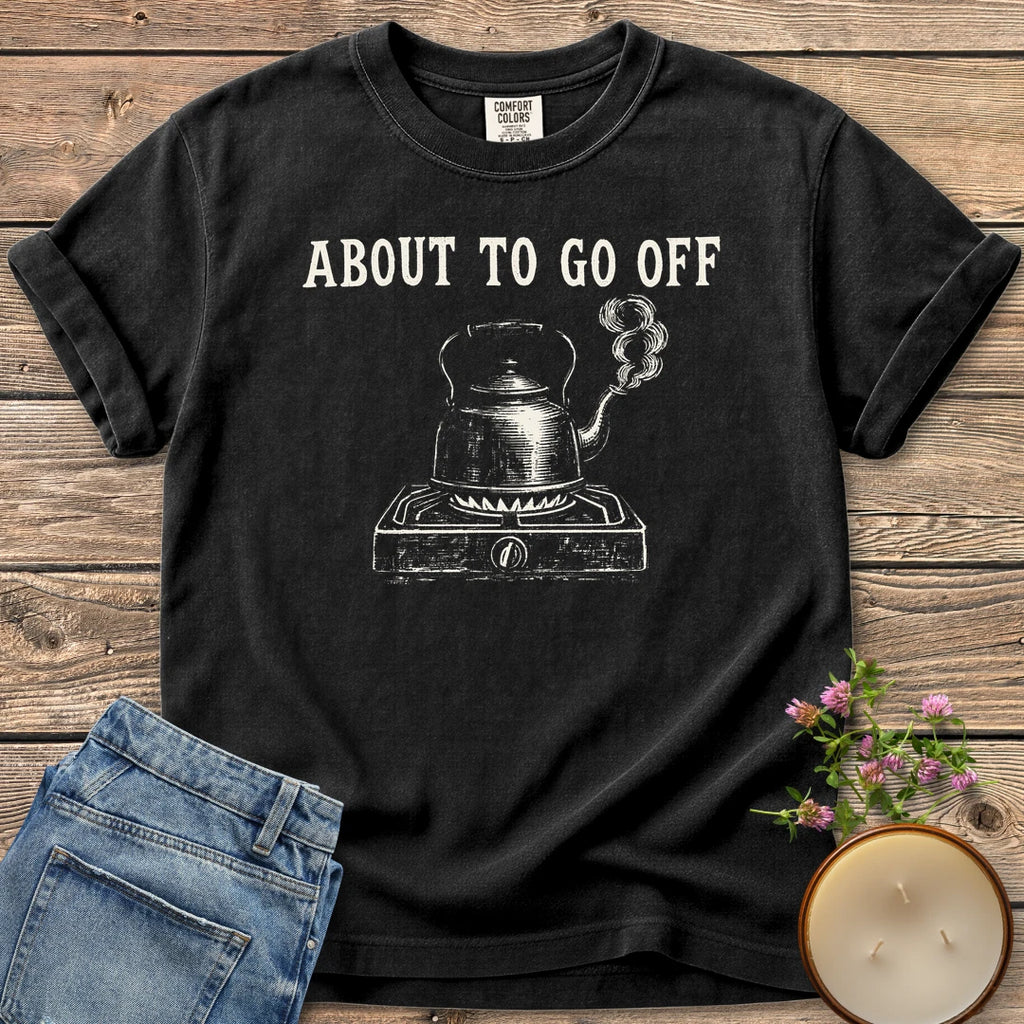 About to Go Off t-shirt, a whistling tea kettle on a burner under About To Go Off, on a Black Comfort Colors tee