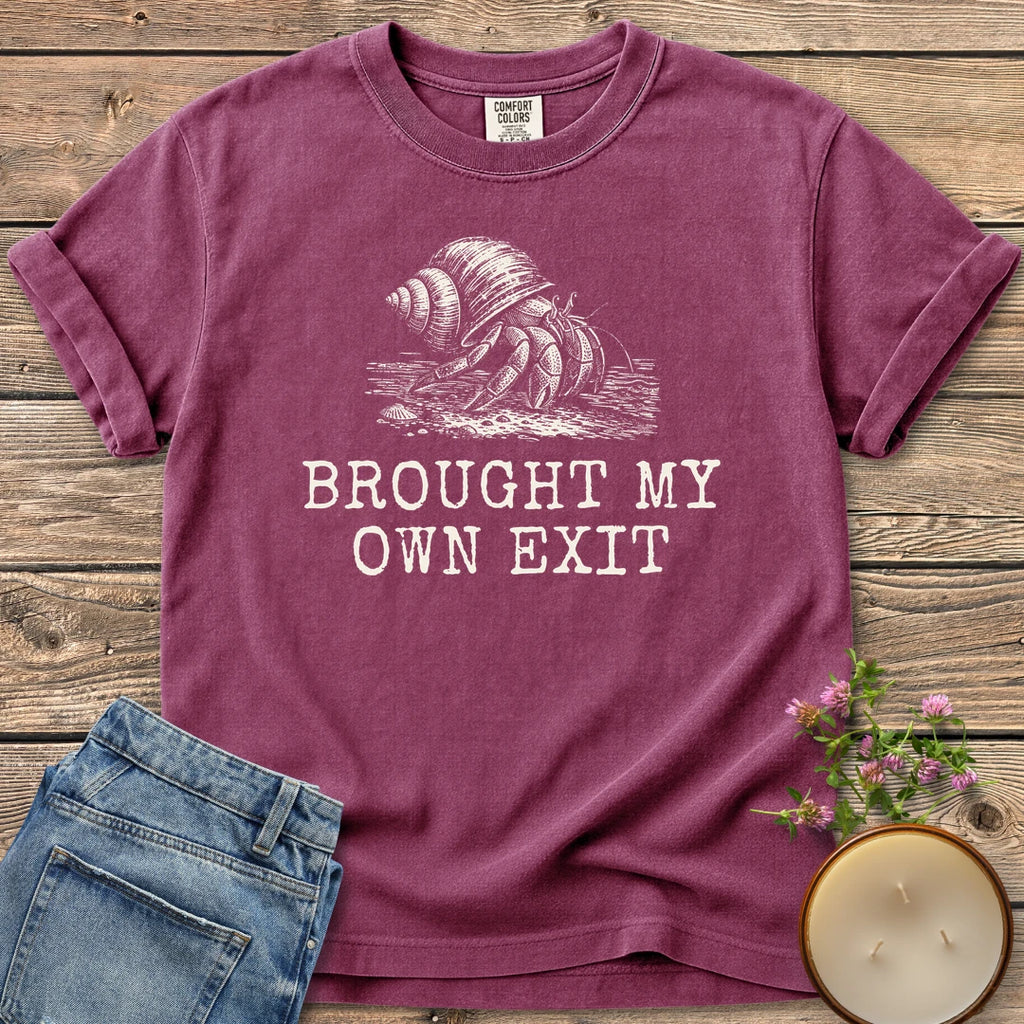 Brought My Own Exit t-shirt, a hermit crab carrying its shell above Brought My Own Exit, on a Berry Comfort Colors tee