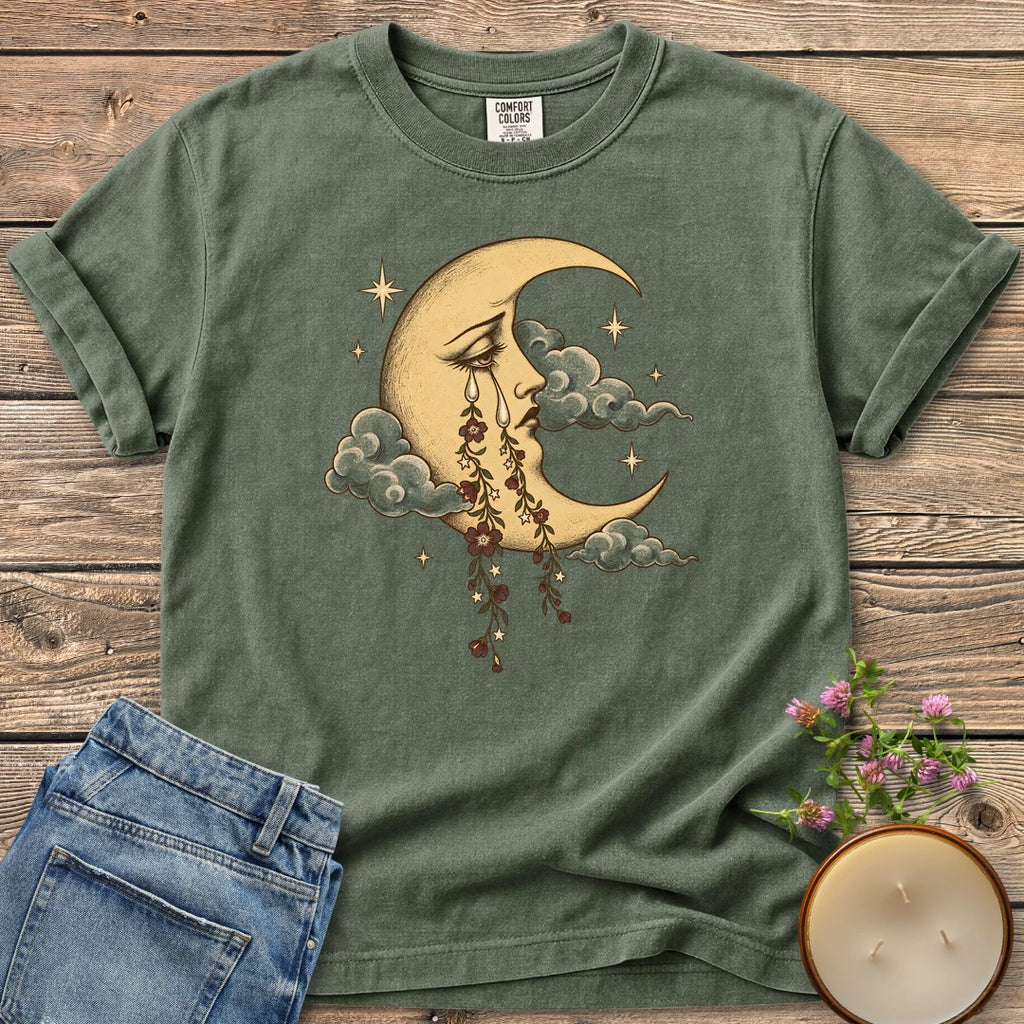 Crescent Moon Floral Tears t-shirt, a crescent moon crying tears of hanging flowers among clouds and stars, on a Moss Comfort Colors tee
