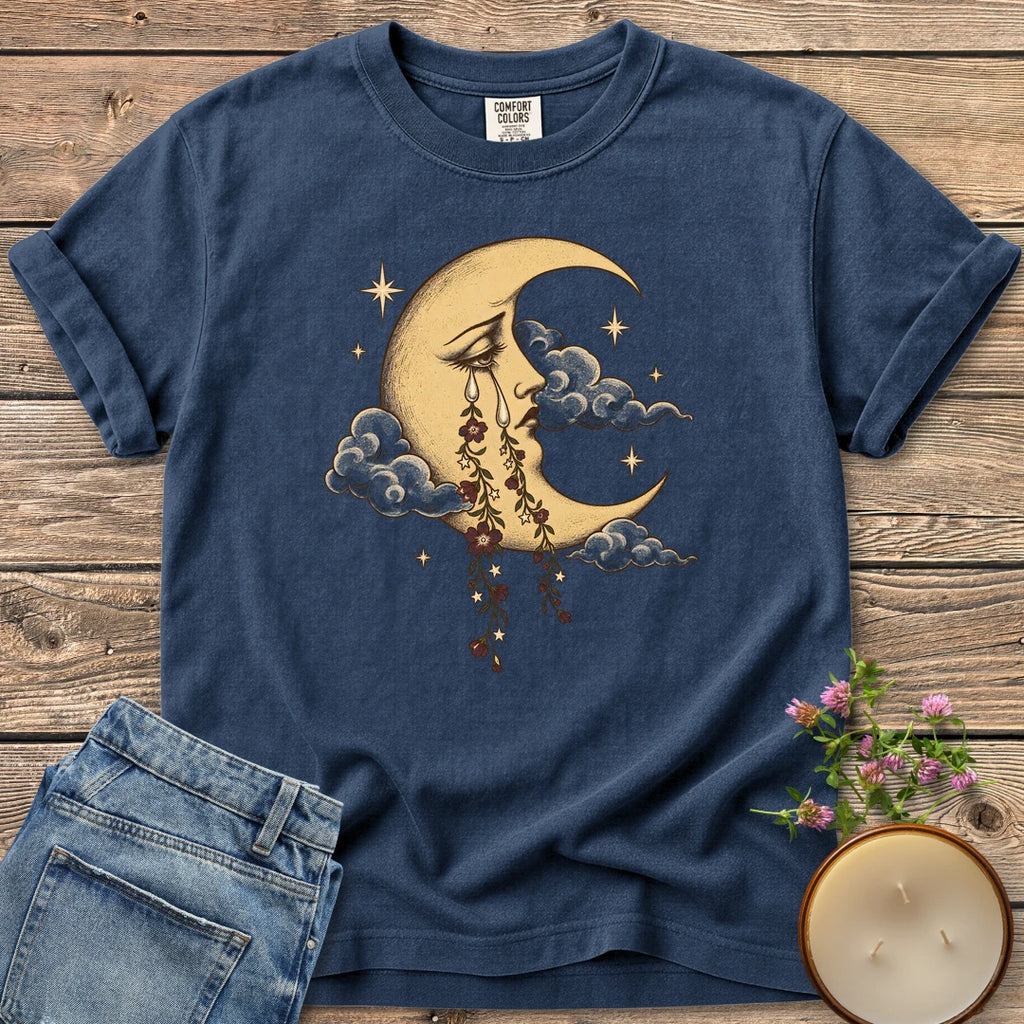 Crescent Moon Floral Tears t-shirt, a crescent moon crying tears of hanging flowers among clouds and stars, on a Navy Comfort Colors tee