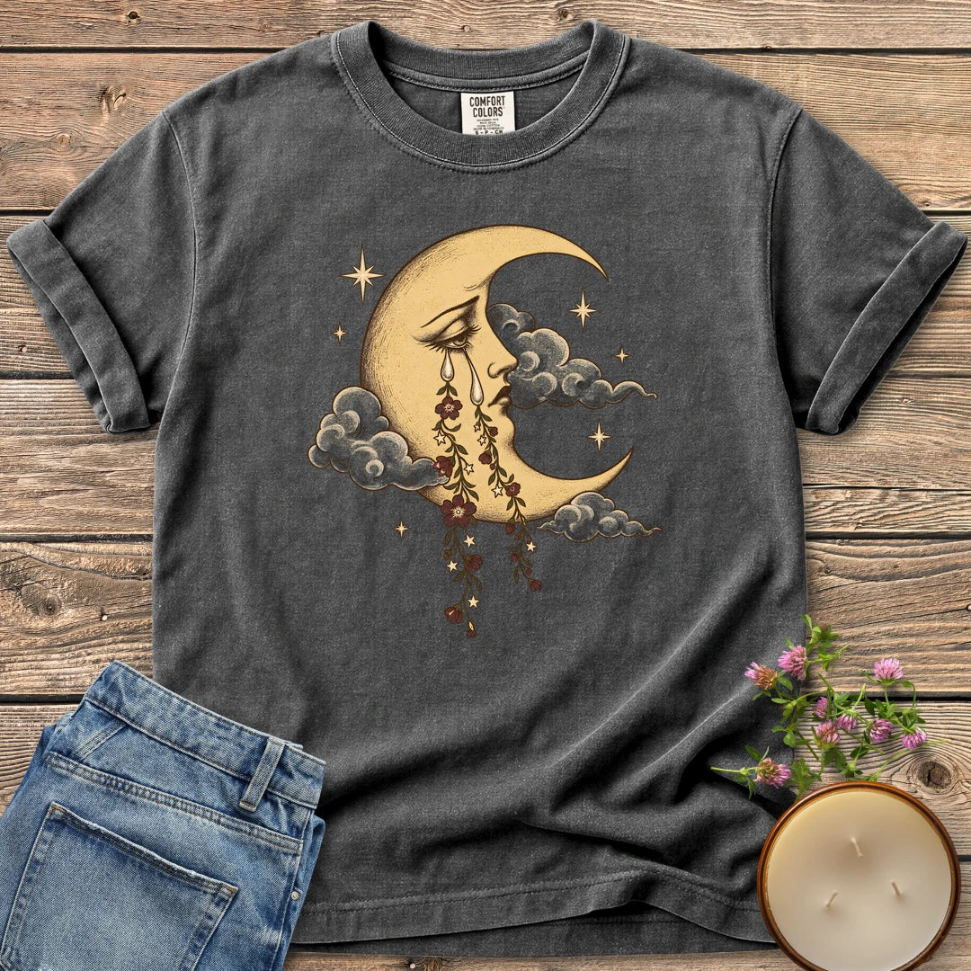 Crescent Moon Floral Tears t-shirt, a crescent moon crying tears of hanging flowers among clouds and stars, on a Pepper Comfort Colors tee