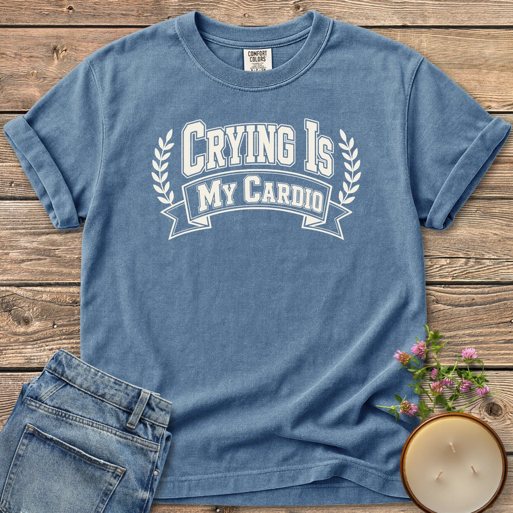 Crying Is My Cardio t-shirt, Crying Is My Cardio in varsity letters on a banner with laurel branches, on a Blue Jean Comfort Colors tee