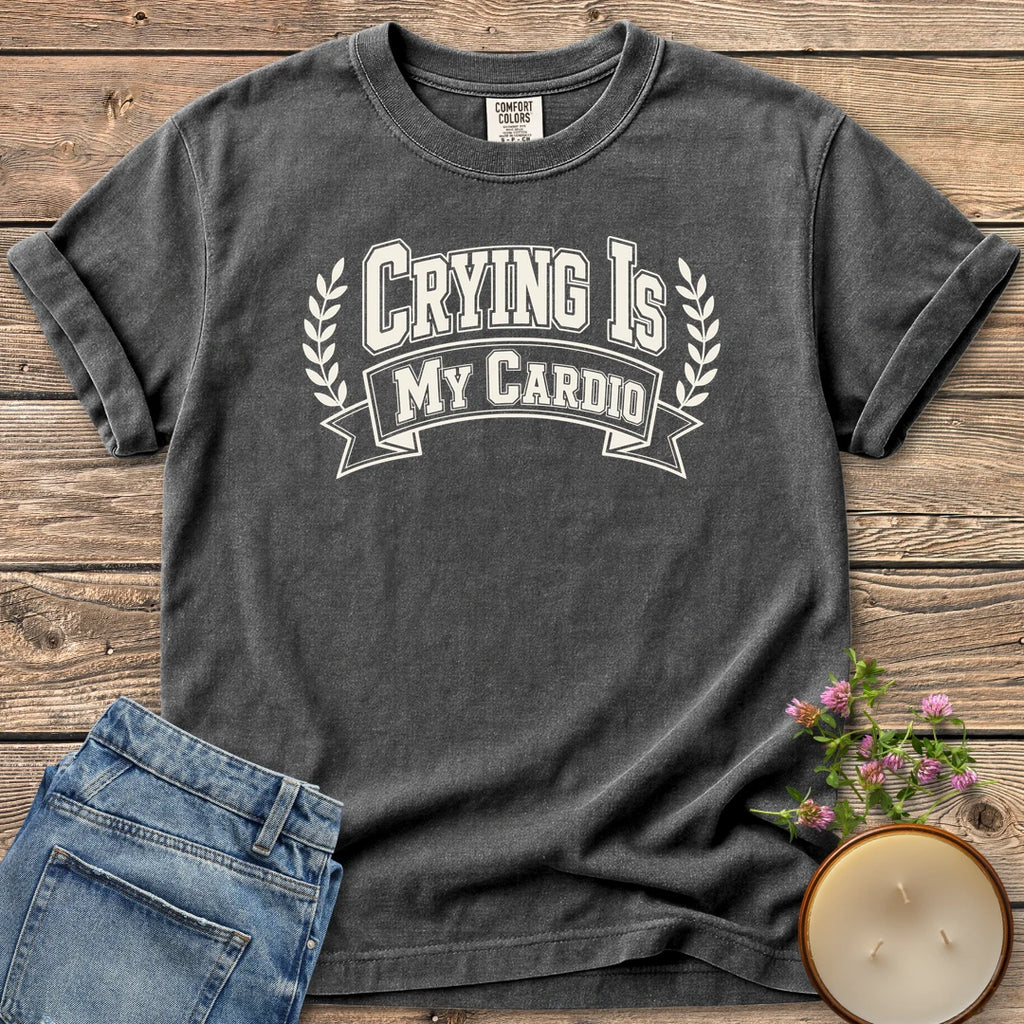 Crying Is My Cardio t-shirt, Crying Is My Cardio in varsity letters on a banner with laurel branches, on a Pepper Comfort Colors tee