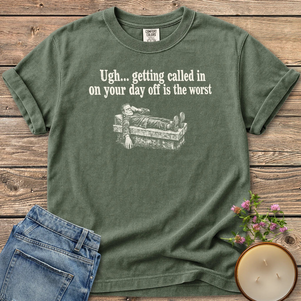 Day Off Is the Worst t-shirt, Frankenstein's monster lying flat on a slab under Ugh... getting called in on your day off is the worst, on a Moss Comfort Colors tee