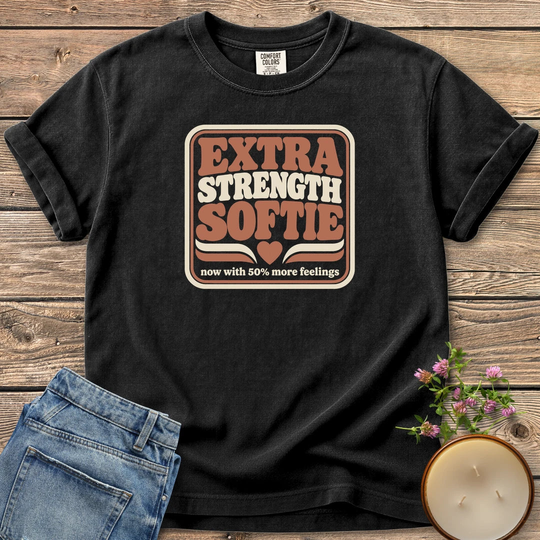 Extra Strength Softie t-shirt, a retro badge reading Extra Strength Softie with a heart and now with 50% more feelings, on a Black Comfort Colors tee