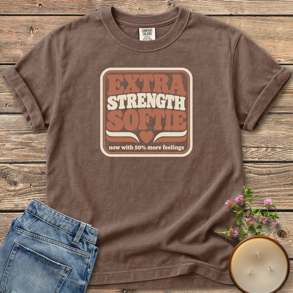 Extra Strength Softie t-shirt, a retro badge reading Extra Strength Softie with a heart and now with 50% more feelings, on an Espresso Comfort Colors tee