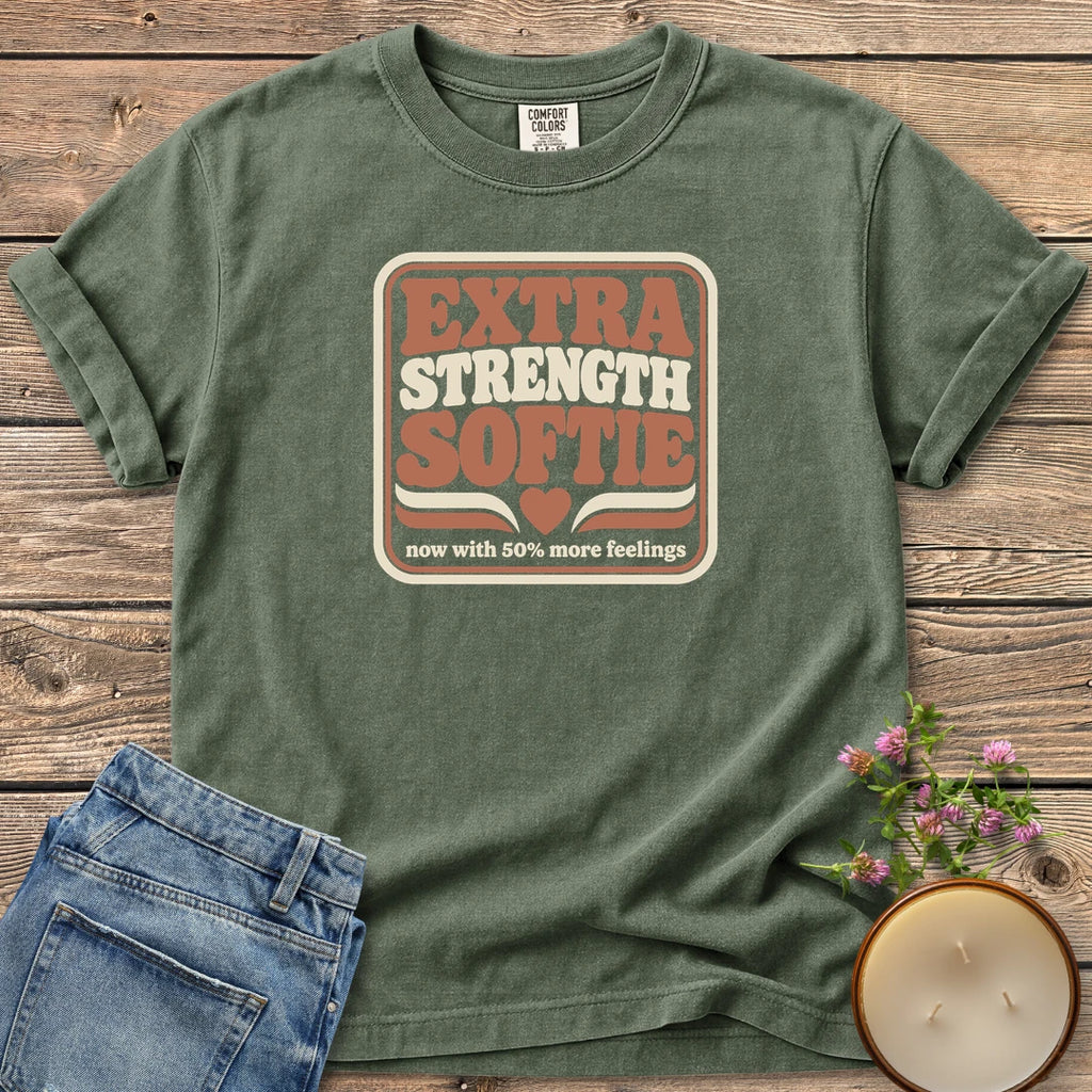Extra Strength Softie t-shirt, a retro badge reading Extra Strength Softie with a heart and now with 50% more feelings, on a Moss Comfort Colors tee