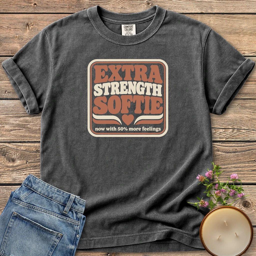 Extra Strength Softie t-shirt, a retro badge reading Extra Strength Softie with a heart and now with 50% more feelings, on a Pepper Comfort Colors tee