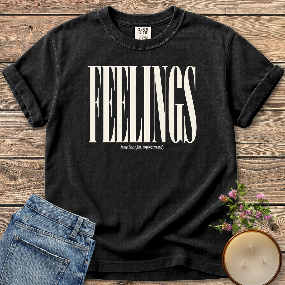 Feelings Unfortunately t-shirt, FEELINGS in tall condensed type with have been felt, unfortunately, on a Black Comfort Colors tee