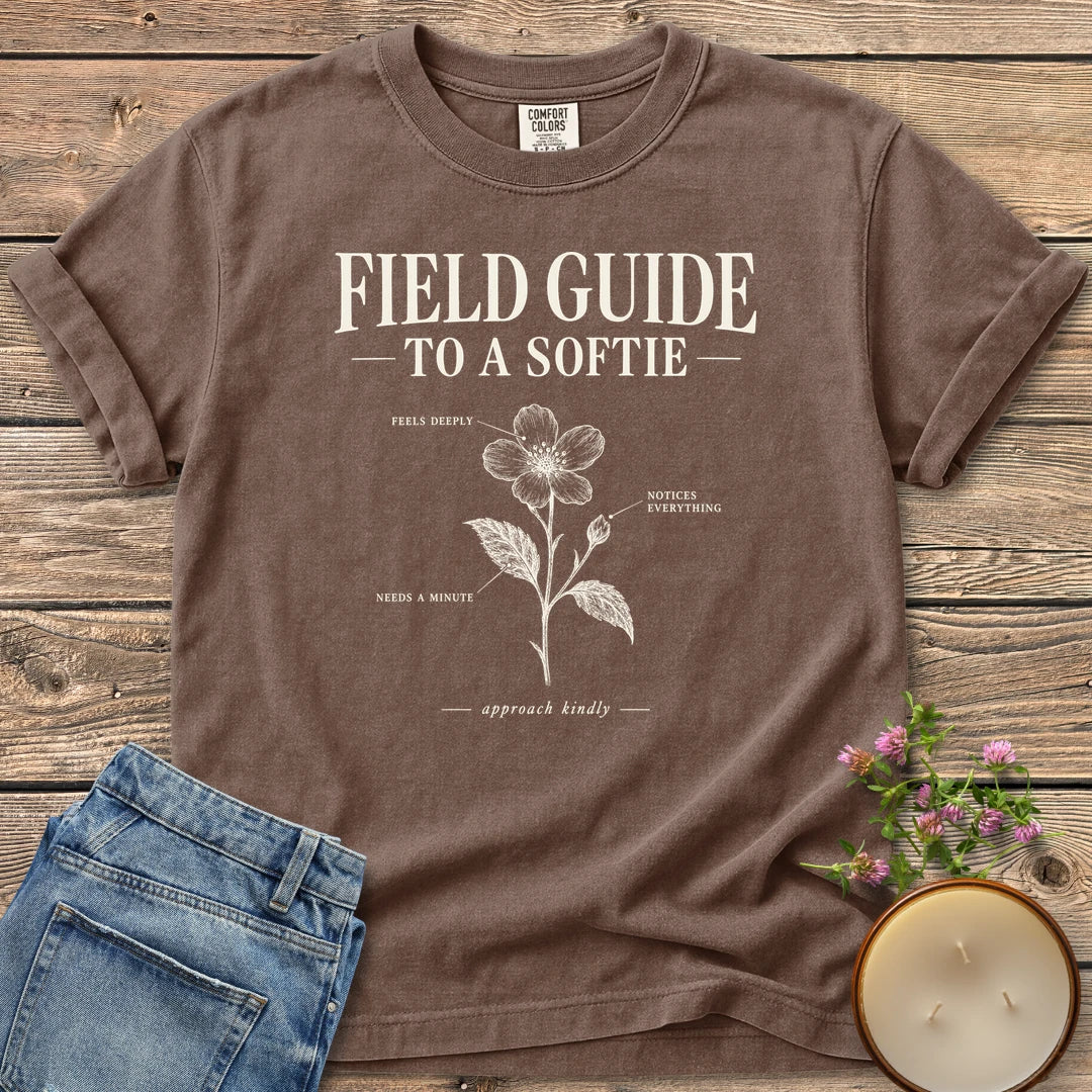 Field Guide To A Softie t-shirt, Field Guide To A Softie with a labeled flower reading feels deeply, notices everything, needs a minute, on an Espresso Comfort Colors tee