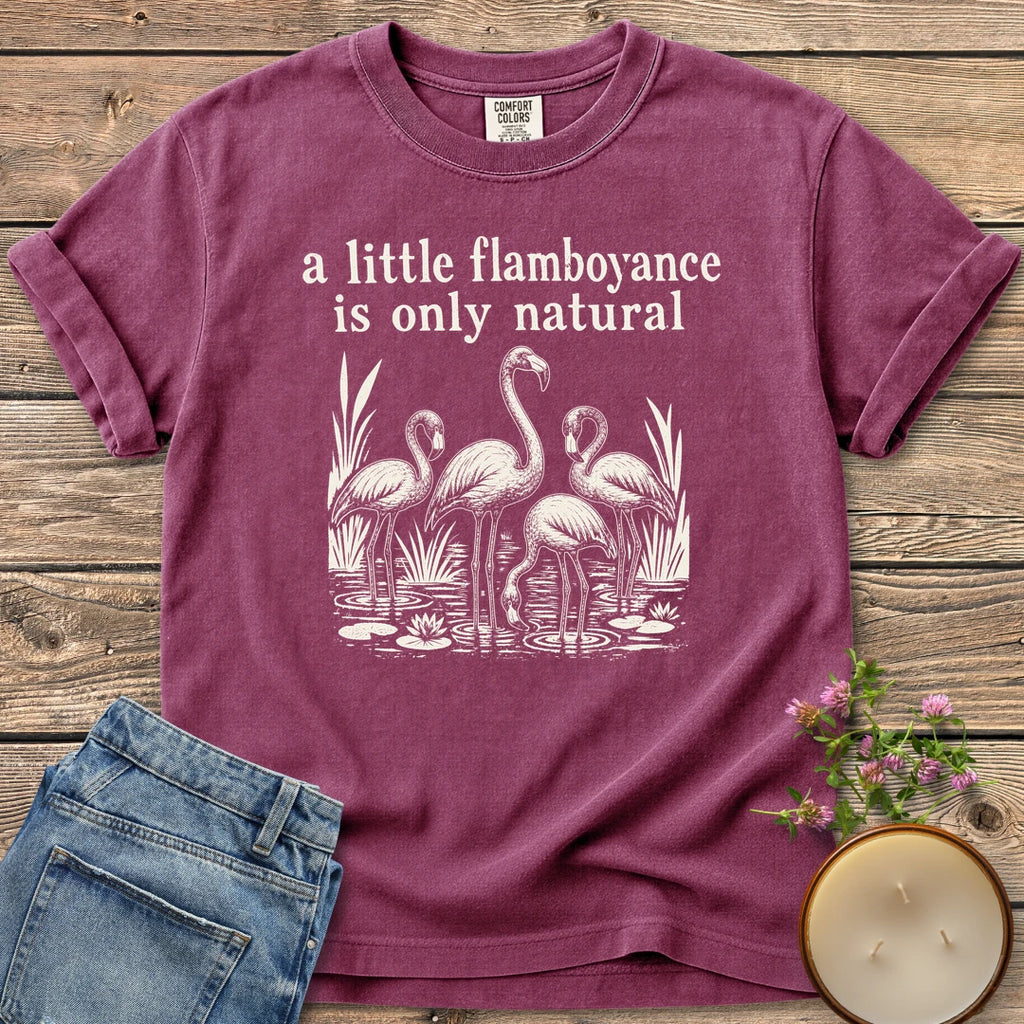 Flamboyance Is Only Natural t-shirt, a group of flamingos wading in a pond under a little flamboyance is only natural, on a Berry Comfort Colors tee