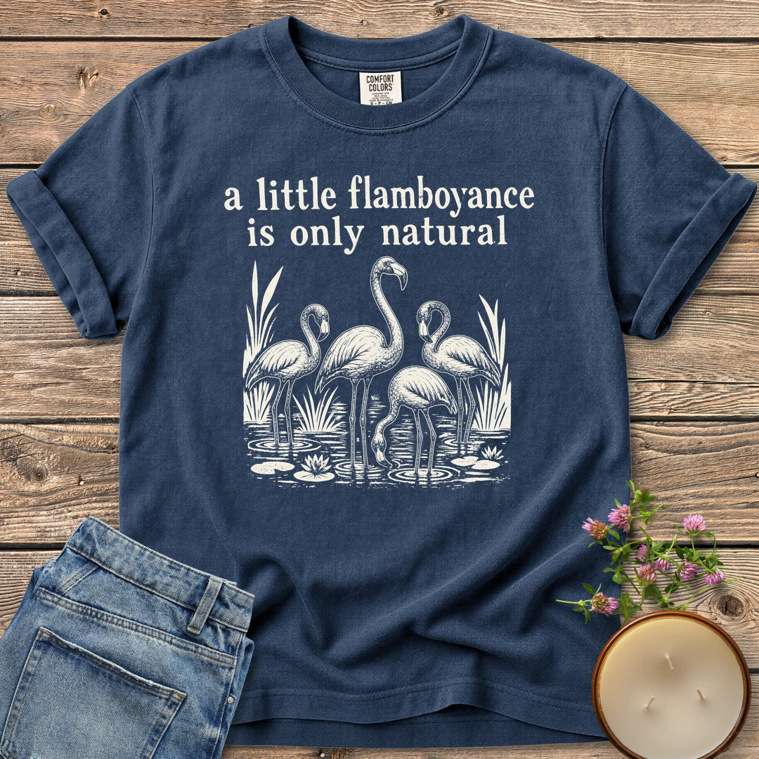 Flamboyance Is Only Natural t-shirt, a group of flamingos wading in a pond under a little flamboyance is only natural, on a Navy Comfort Colors tee