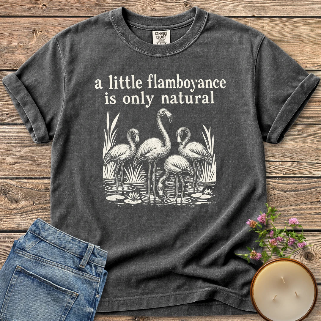 Flamboyance Is Only Natural t-shirt, a group of flamingos wading in a pond under a little flamboyance is only natural, on a Pepper Comfort Colors tee