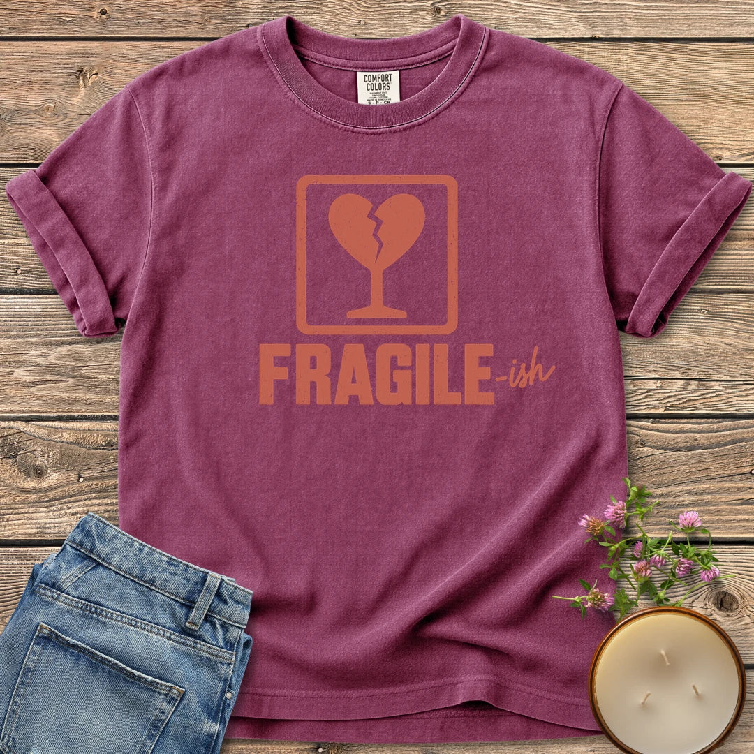 Fragile-ish t-shirt, a shipping label with a broken heart and cracked glass above Fragile-ish, on a Berry Comfort Colors tee