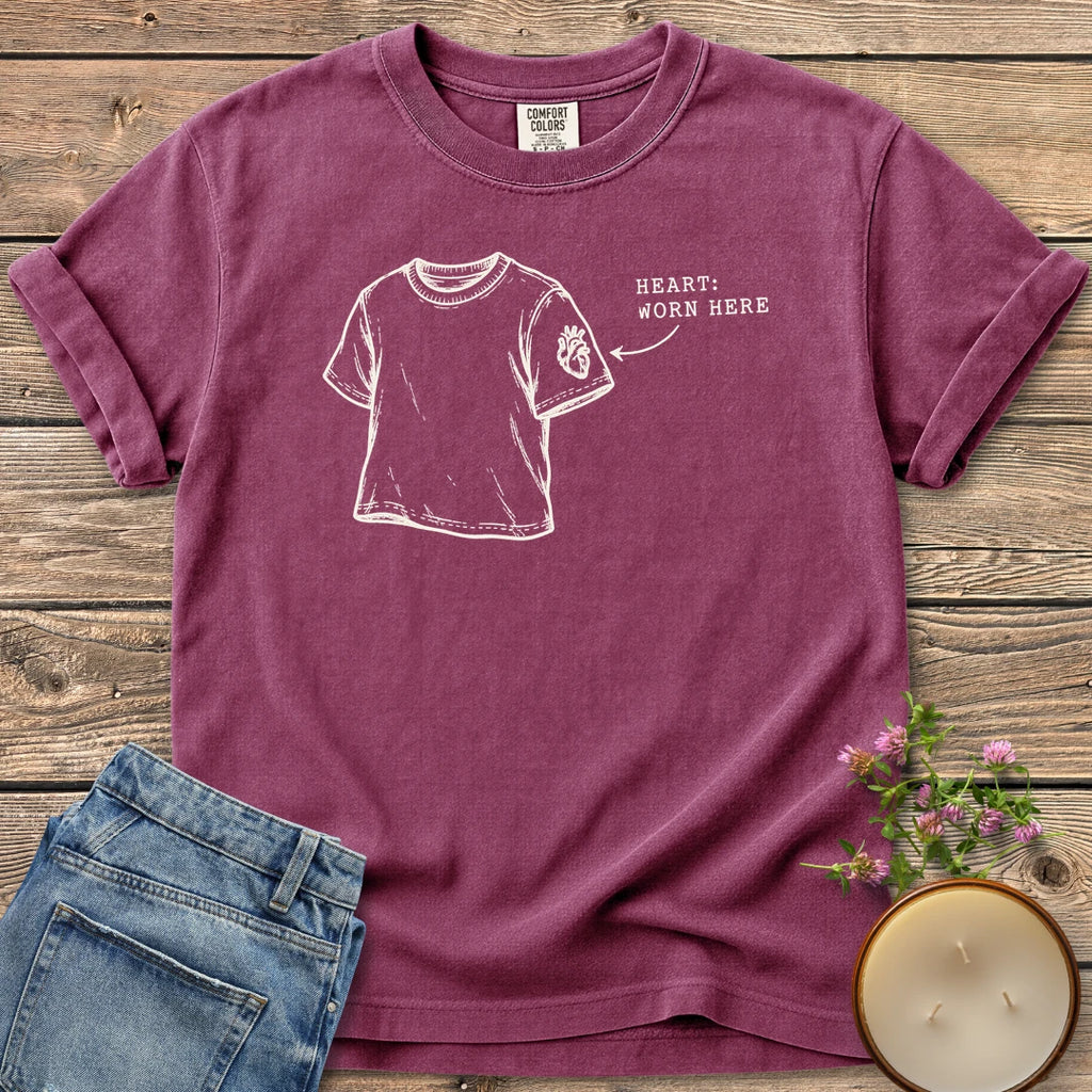 Heart Worn Here t-shirt, a sketched t-shirt with an anatomical heart on the sleeve and Heart: Worn Here, on a Berry Comfort Colors tee
