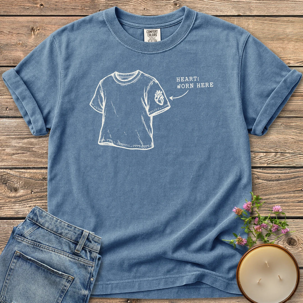 Heart Worn Here t-shirt, a sketched t-shirt with an anatomical heart on the sleeve and Heart: Worn Here, on a Blue Jean Comfort Colors tee