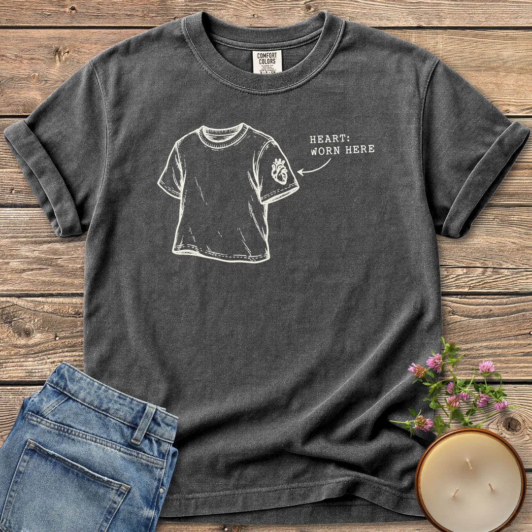 Heart Worn Here t-shirt, a sketched t-shirt with an anatomical heart on the sleeve and Heart: Worn Here, on a Pepper Comfort Colors tee