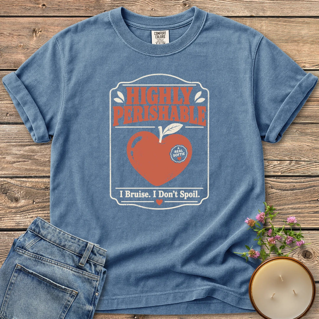 I Bruise I Don't Spoil t-shirt, a vintage label reading Highly Perishable with a heart-shaped apple and I Bruise. I Don't Spoil, on a Blue Jean Comfort Colors tee