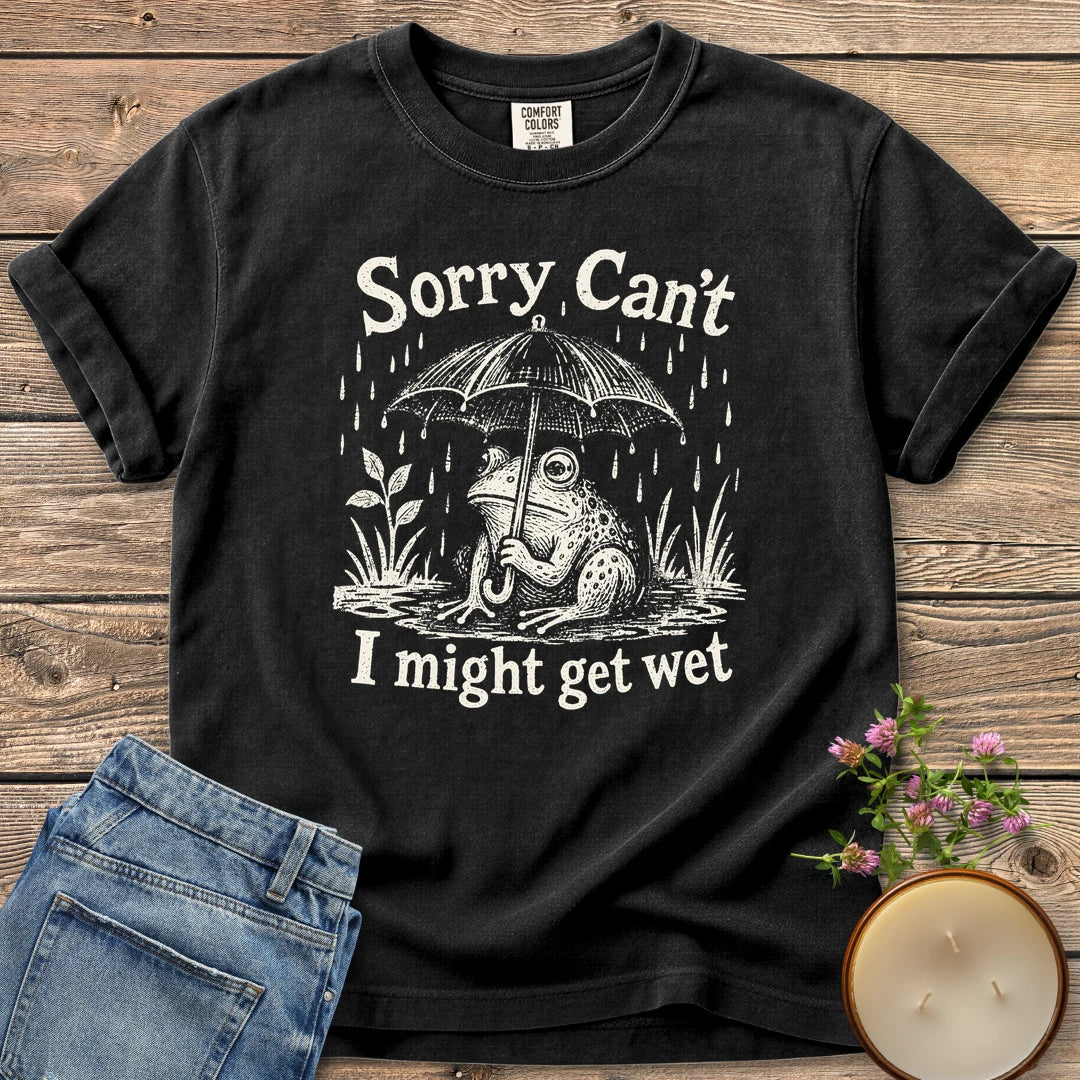 I Might Get Wet t-shirt, a frog under an umbrella in the rain between Sorry Can't and I might get wet, on a Black Comfort Colors tee