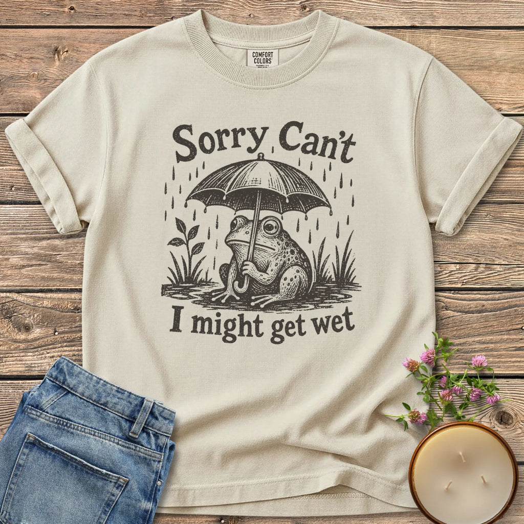 I Might Get Wet t-shirt, a frog under an umbrella in the rain between Sorry Can't and I might get wet, on an Ivory Comfort Colors tee