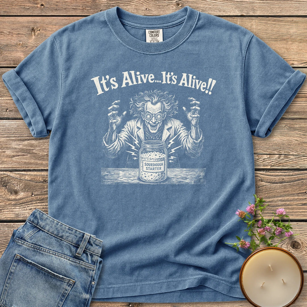 It's Alive t-shirt, a mad scientist celebrating a bubbling sourdough starter jar under It's Alive... It's Alive!!, on a Blue Jean Comfort Colors tee