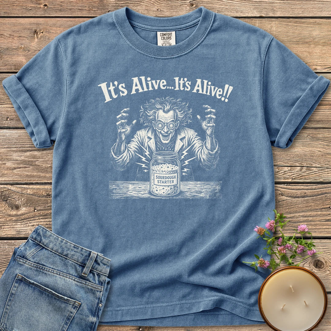 It's Alive t-shirt, a mad scientist celebrating a bubbling sourdough starter jar under It's Alive... It's Alive!!, on a Blue Jean Comfort Colors tee