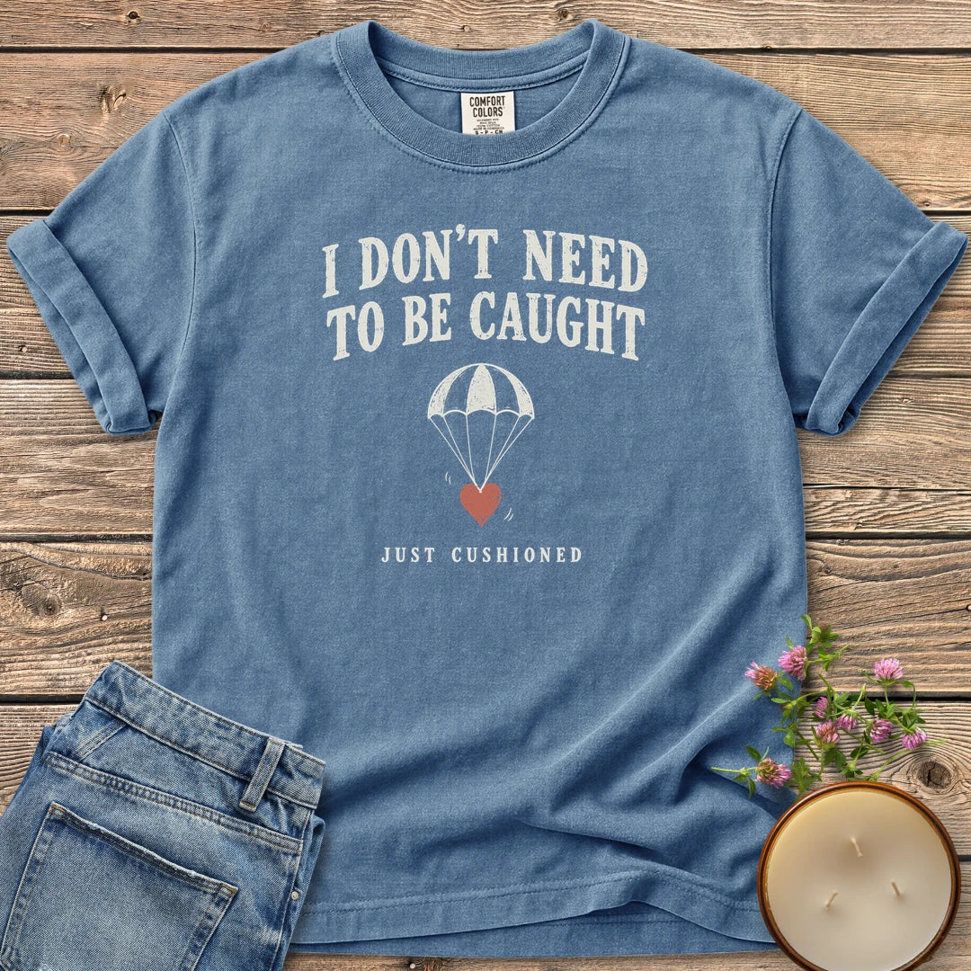 Just Cushioned t-shirt, I Don't Need To Be Caught with a heart on a parachute and Just Cushioned, on a Blue Jean Comfort Colors tee