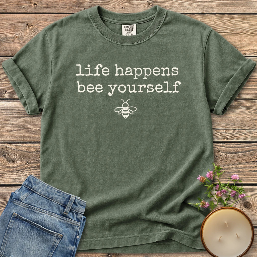 Life Happens Bee Yourself t-shirt, life happens bee yourself in typewriter type with a small bee, on a Moss Comfort Colors tee