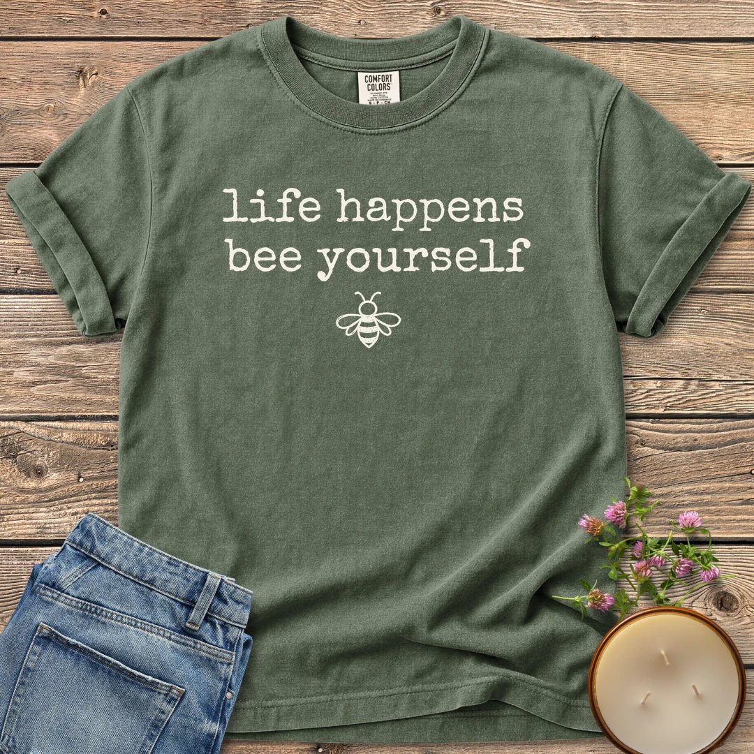 Life Happens Bee Yourself t-shirt, life happens bee yourself in typewriter type with a small bee, on a Moss Comfort Colors tee
