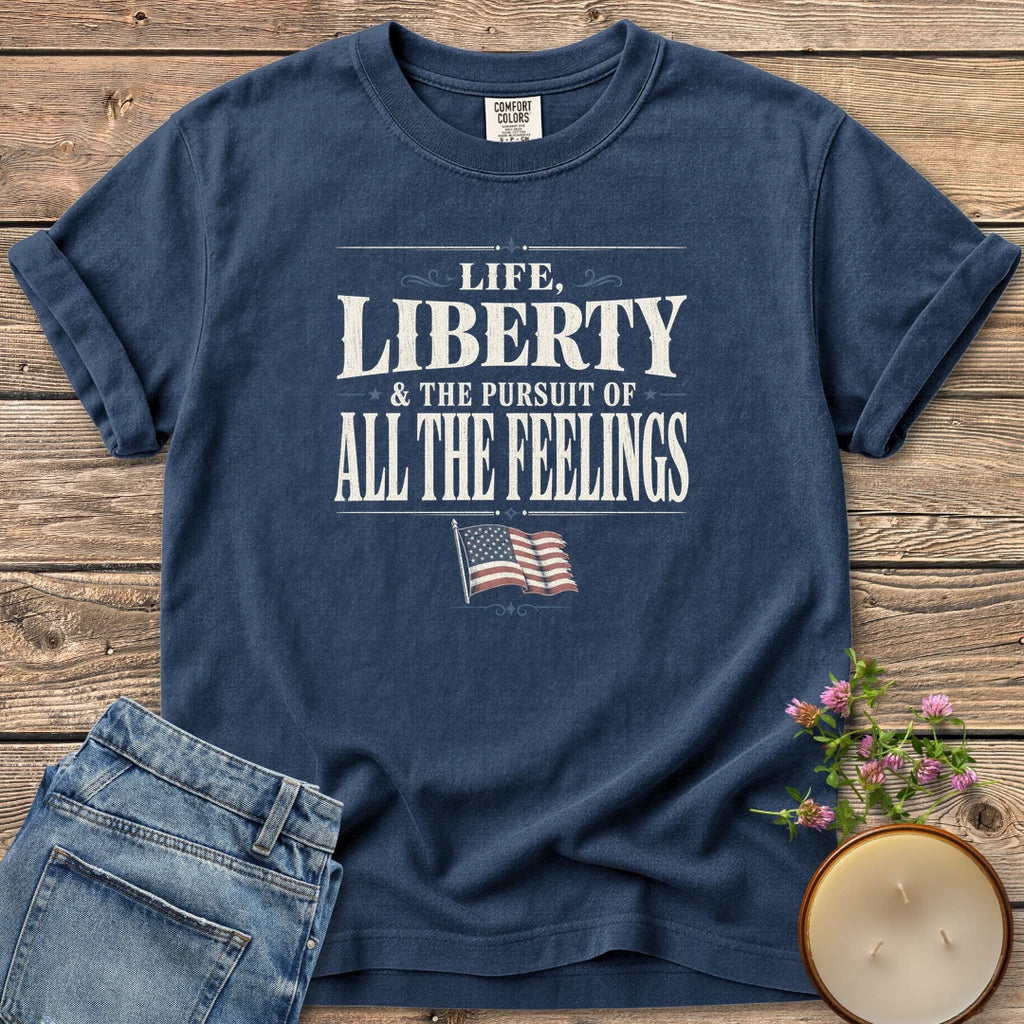 Life Liberty All the Feelings t-shirt, Life, Liberty & The Pursuit of All The Feelings in vintage type with a waving American flag, on a Navy Comfort Colors tee