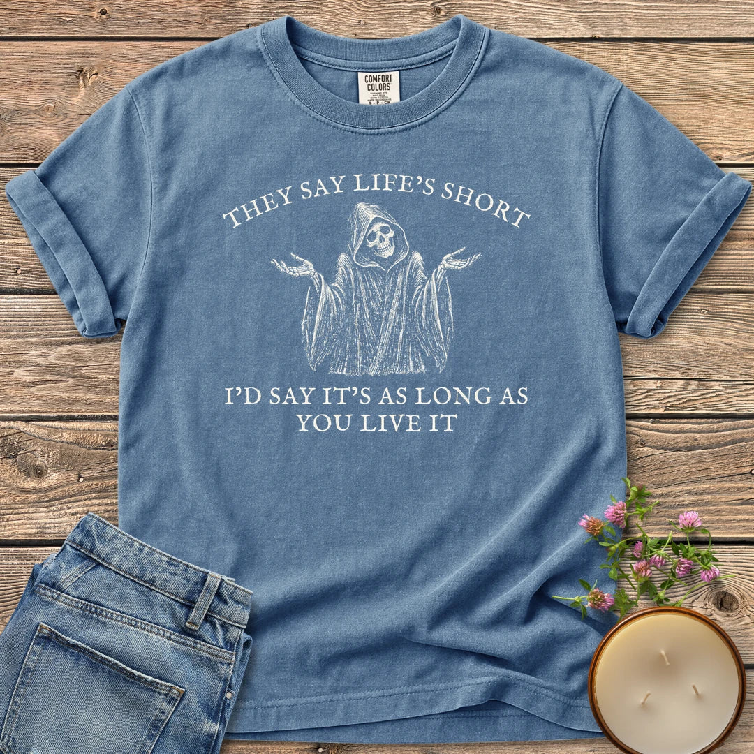 Long As You Live It t-shirt, a shrugging grim reaper between They Say Life's Short and I'd Say It's As Long As You Live It, on a Blue Jean Comfort Colors tee
