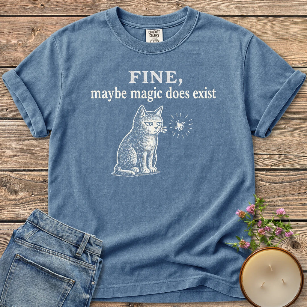 Maybe Magic Does Exist t-shirt, a grumpy cat watching a firefly under Fine, maybe magic does exist, on a Blue Jean Comfort Colors tee