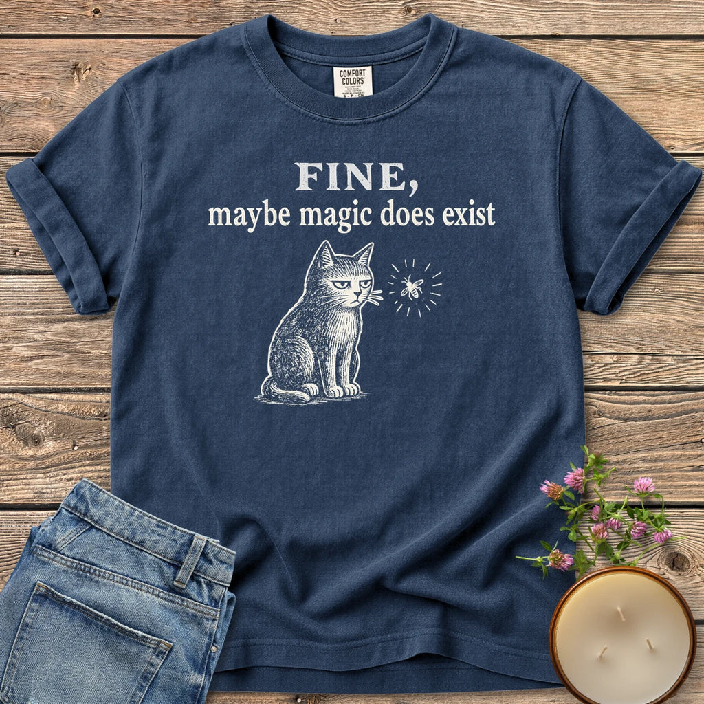 Maybe Magic Does Exist t-shirt, a grumpy cat watching a firefly under Fine, maybe magic does exist, on a Navy Comfort Colors tee