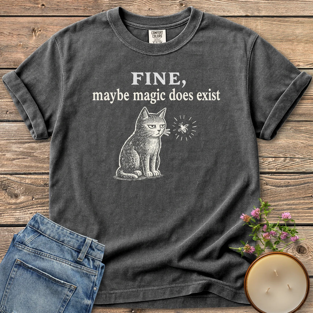 Maybe Magic Does Exist t-shirt, a grumpy cat watching a firefly under Fine, maybe magic does exist, on a Pepper Comfort Colors tee