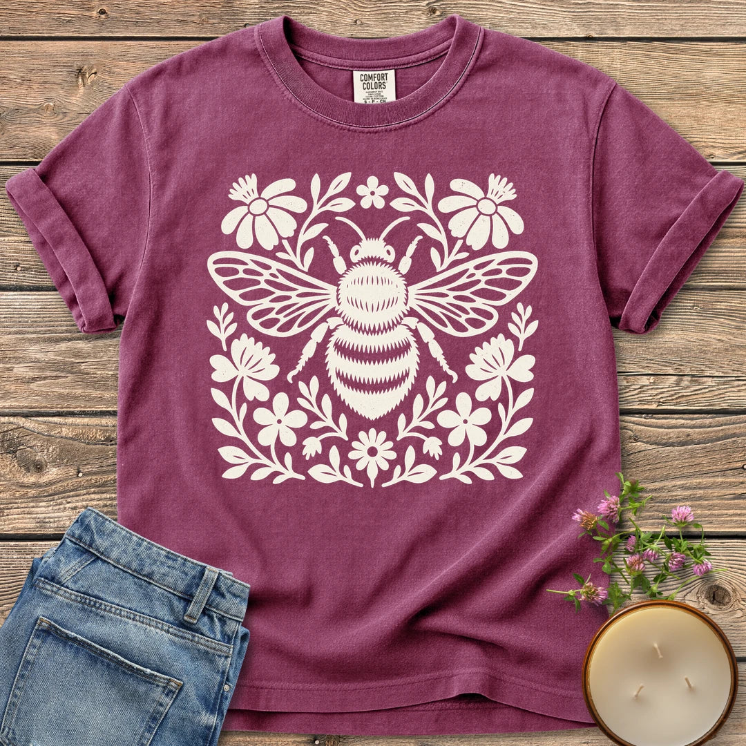 Meadow Bee Folk Art Flat t-shirt, a folk art bee surrounded by flat wildflowers, on a Berry Comfort Colors tee