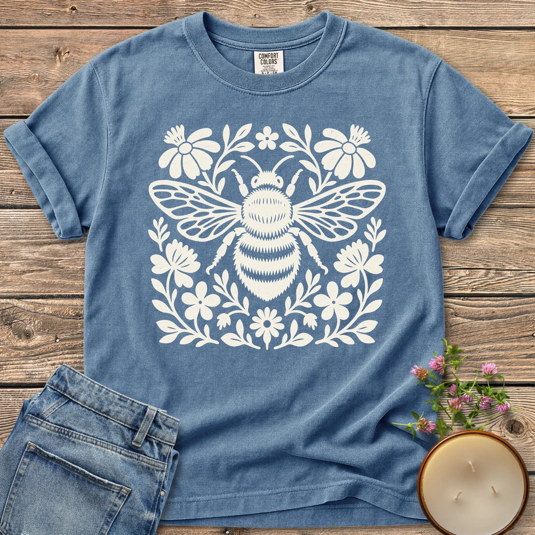 Meadow Bee Folk Art Flat t-shirt, a folk art bee surrounded by flat wildflowers, on a Blue Jean Comfort Colors tee