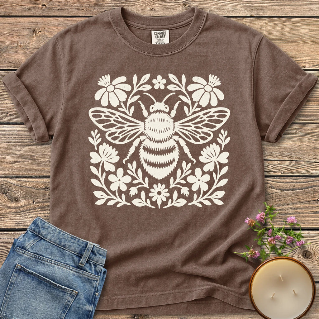 Meadow Bee Folk Art Flat t-shirt, a folk art bee surrounded by flat wildflowers, on an Espresso Comfort Colors tee