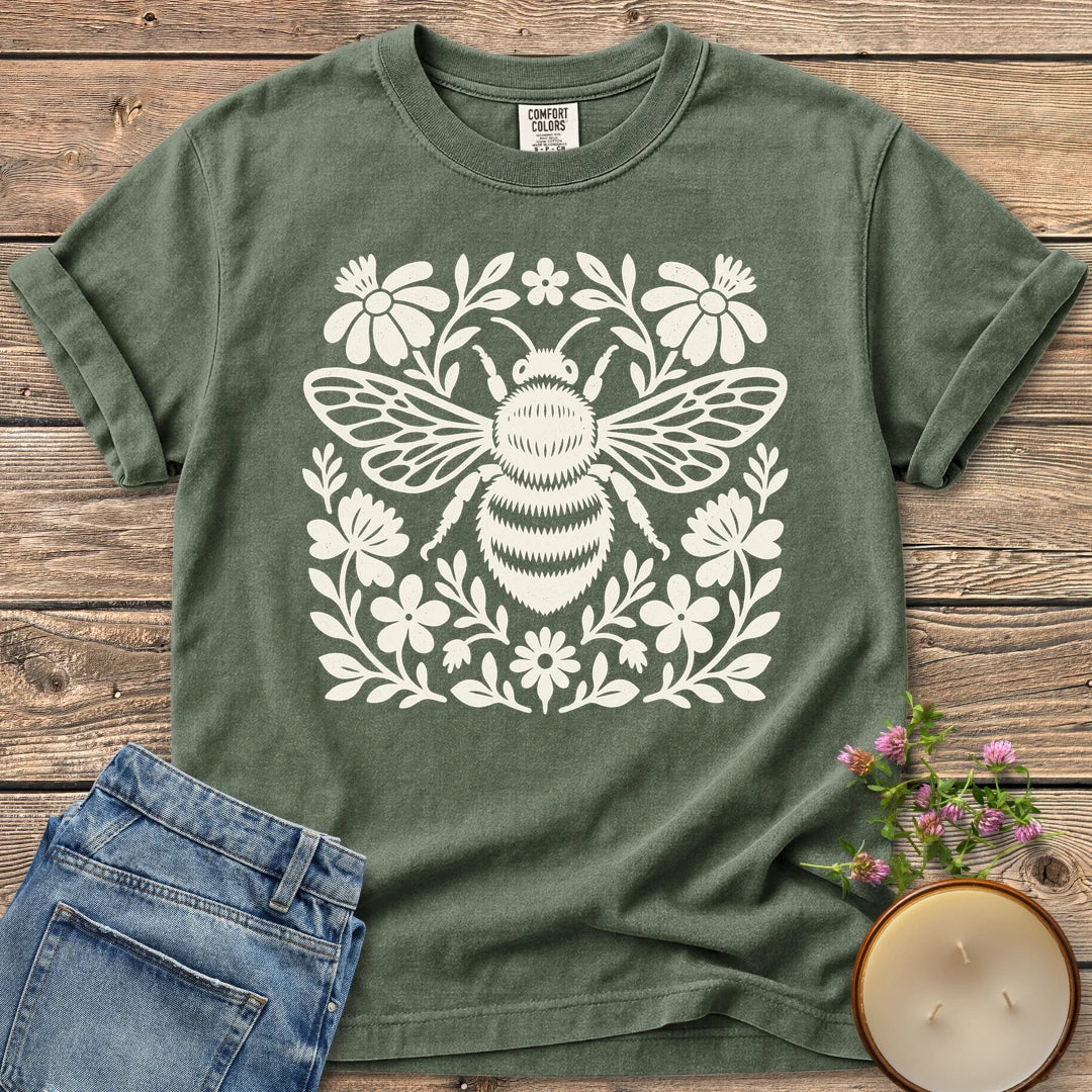 Meadow Bee Folk Art Flat t-shirt, a folk art bee surrounded by flat wildflowers, on a Moss Comfort Colors tee