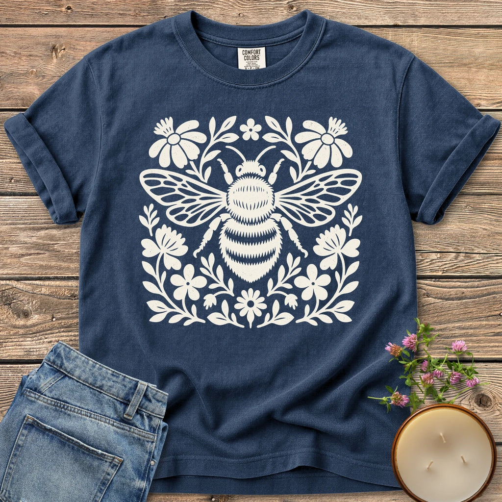 Meadow Bee Folk Art Flat t-shirt, a folk art bee surrounded by flat wildflowers, on a Navy Comfort Colors tee
