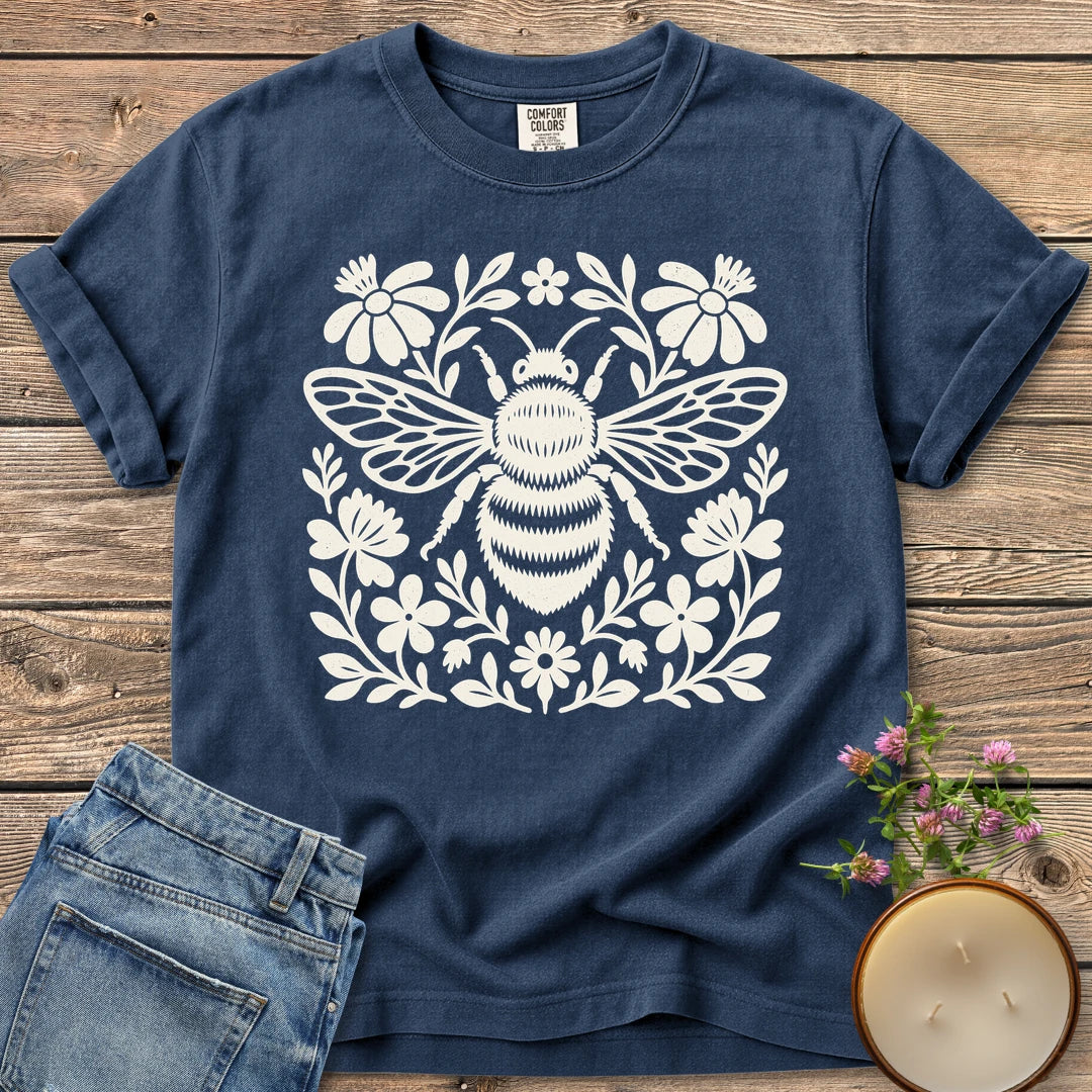 Meadow Bee Folk Art Flat t-shirt, a folk art bee surrounded by flat wildflowers, on a Navy Comfort Colors tee