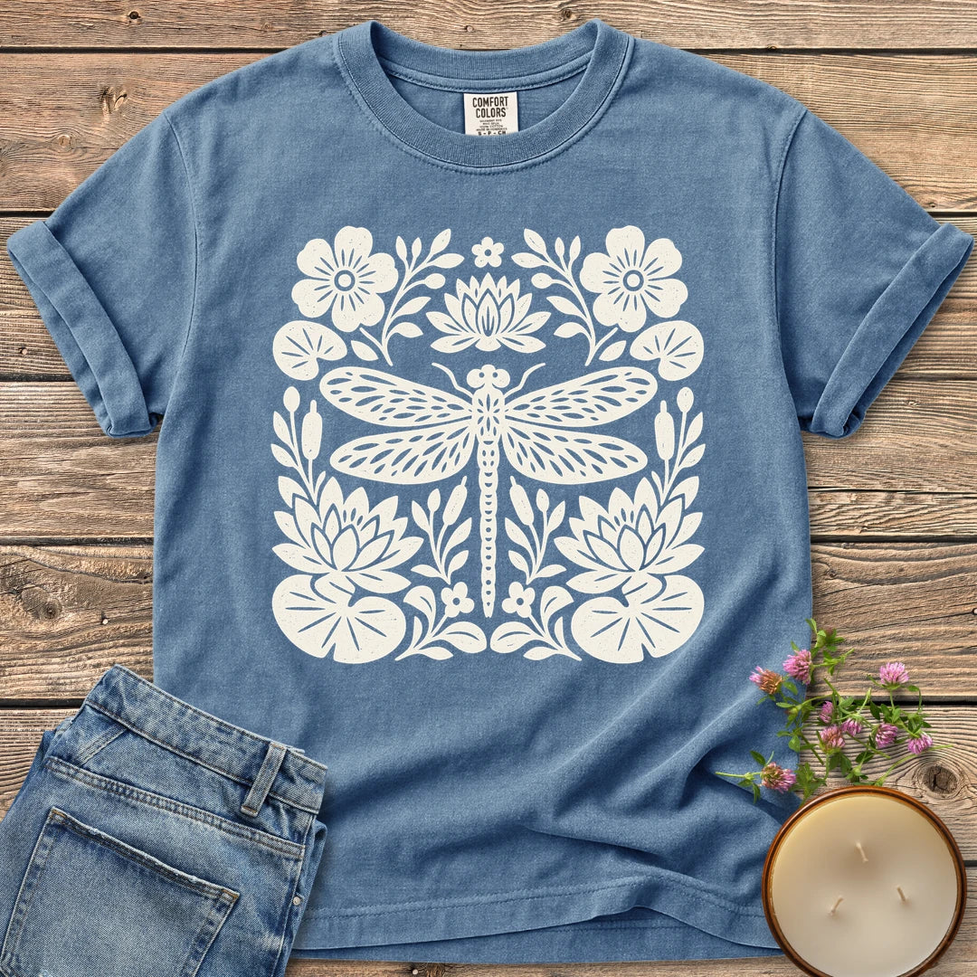 Meadow Dragonfly Folk Art Flat t-shirt, a folk art dragonfly surrounded by lily pads and flowers, on a Blue Jean Comfort Colors tee