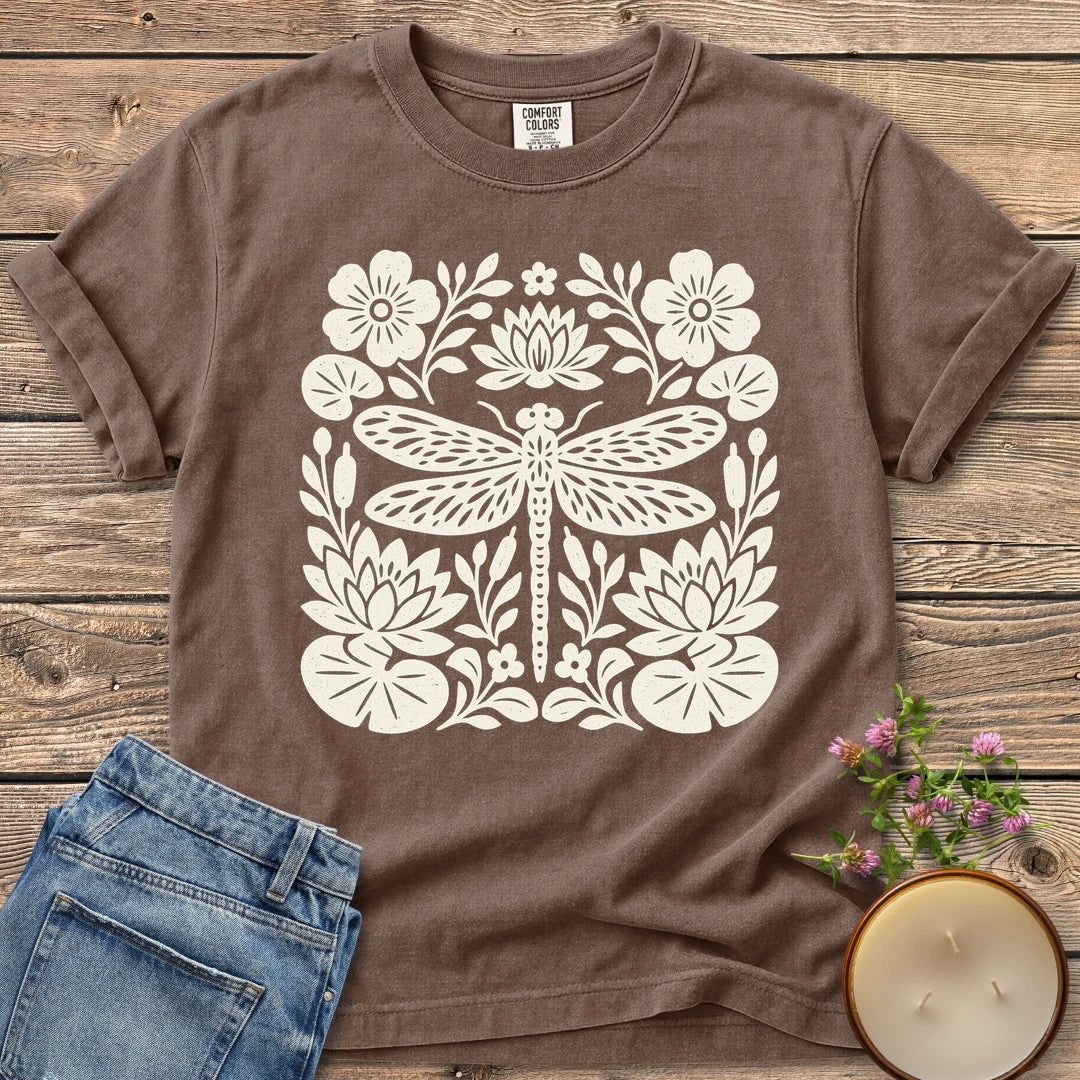 Meadow Dragonfly Folk Art Flat t-shirt, a folk art dragonfly surrounded by lily pads and flowers, on an Espresso Comfort Colors tee
