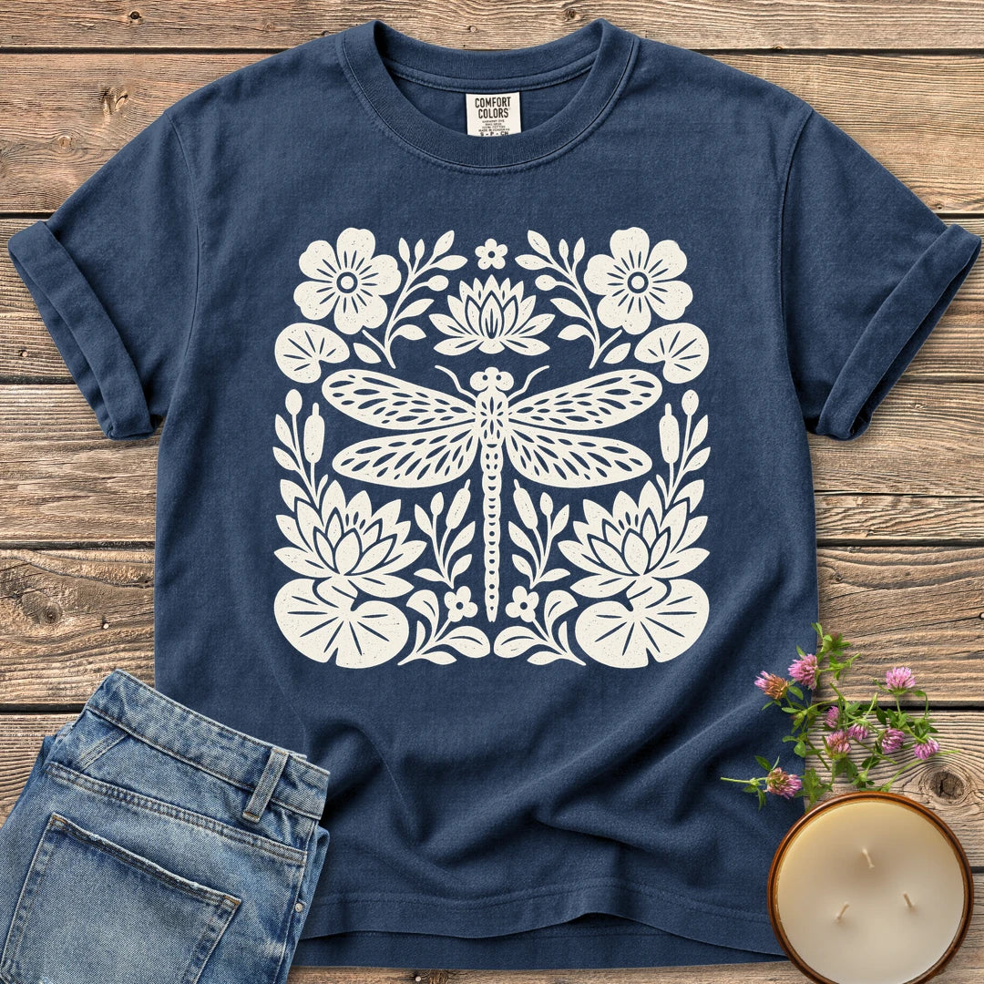 Meadow Dragonfly Folk Art Flat t-shirt, a folk art dragonfly surrounded by lily pads and flowers, on a Navy Comfort Colors tee