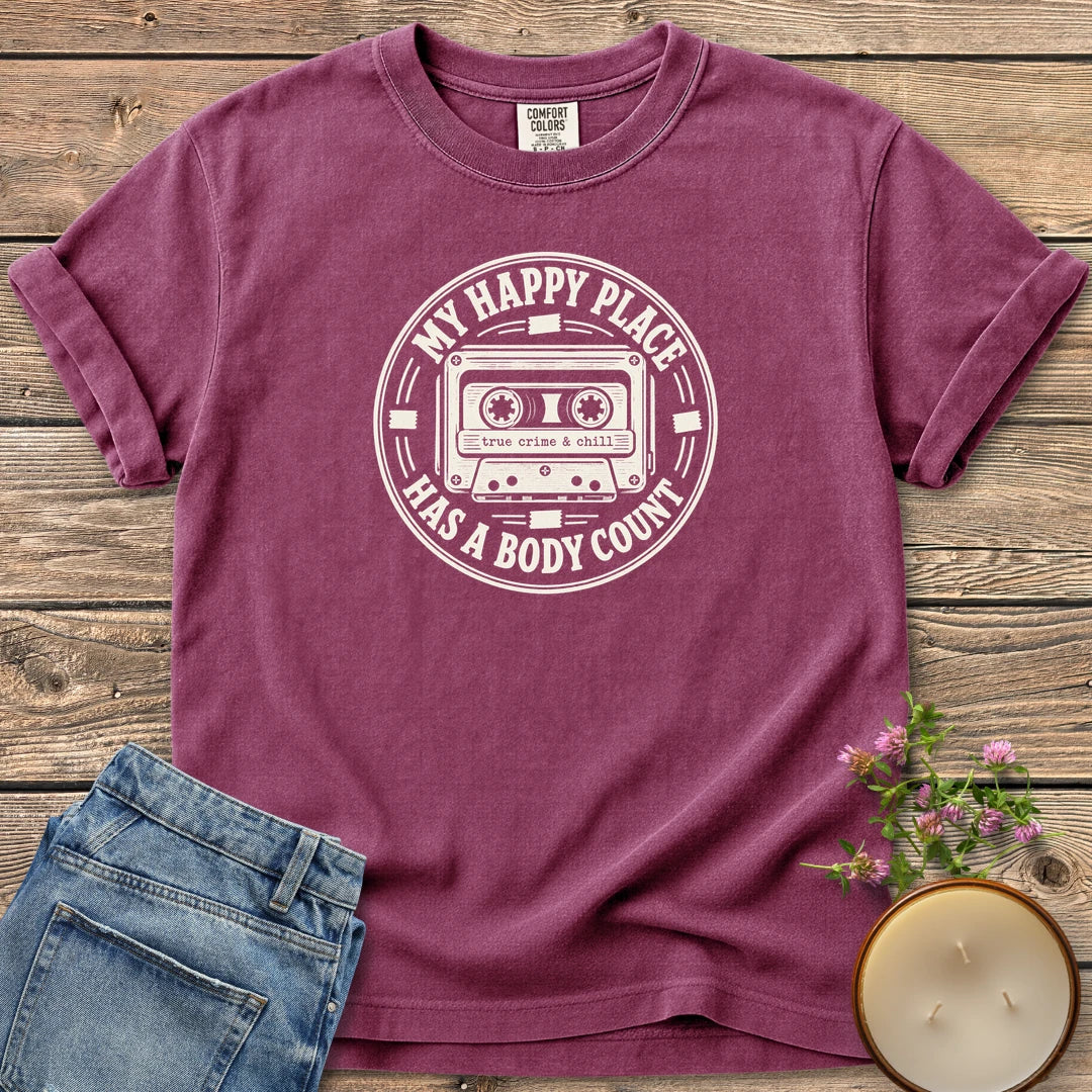 My Happy Place Body Count t-shirt, a round badge with a cassette tape reading My Happy Place Has A Body Count and true crime & chill, on a Berry Comfort Colors tee