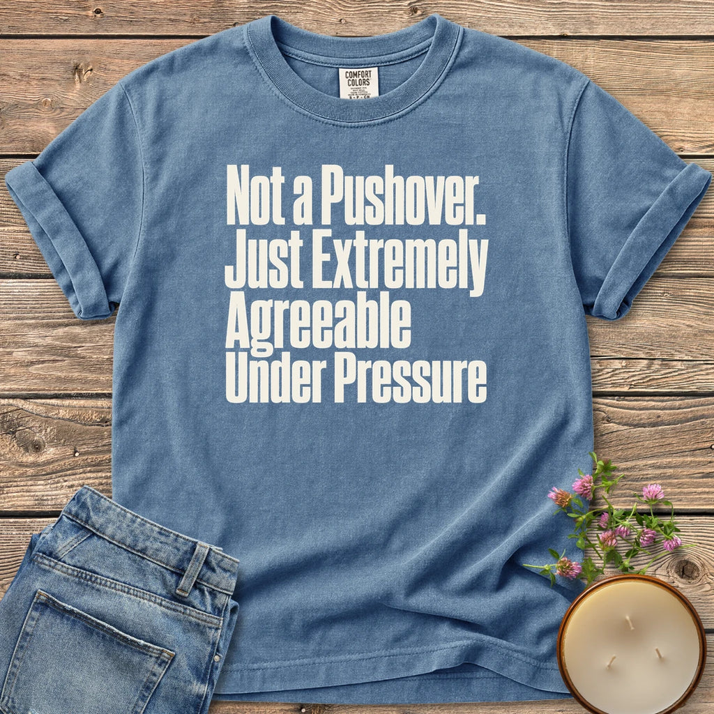 Not a Pushover t-shirt, Not a Pushover. Just Extremely Agreeable Under Pressure in bold condensed type, on a Blue Jean Comfort Colors tee